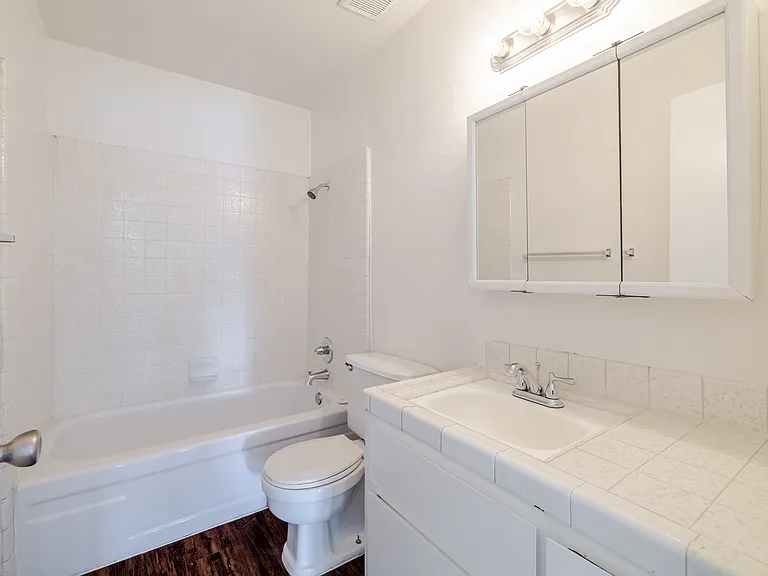 Bright bathroom #1 with a full bathtub and lots of vanity storage.