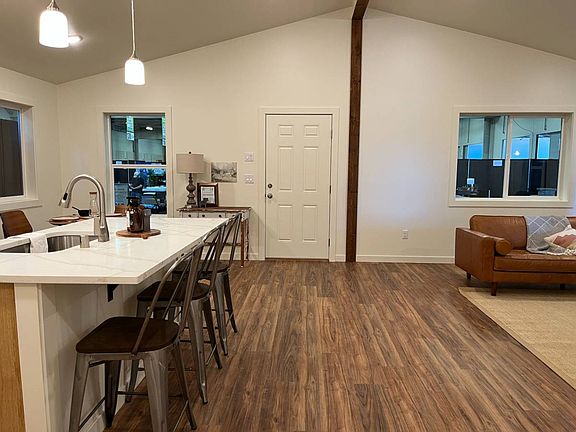 This picture showcases the kitchen island and part of the living room for this unit. It was provided by the manufacturer for visualization purposes.