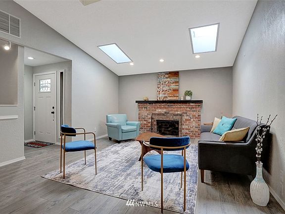Vaulted ceiling, skylights, and beautiful brick fireplace make for a grand entry into the home