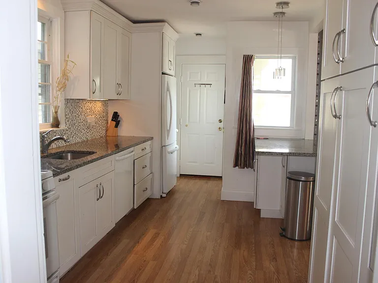 Kitchen view from Foyer between living room. full size pantry on right side kitchen wall