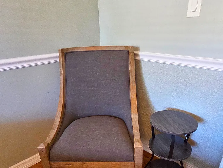 Cozy accent chair with side table perfect for reading or relaxing.