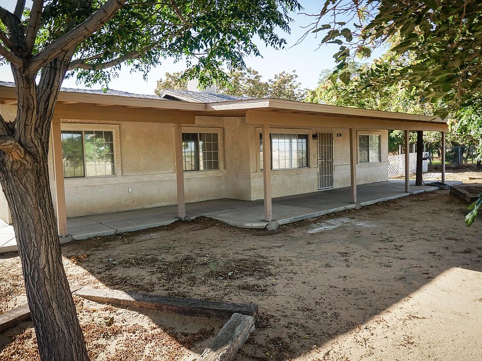 Main entrance to home showing large covered porch and mature shade trees
