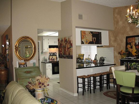 Open floor plan includes a kitchen with granite counters and newer appliances, lots of tile flooring and vaulted ceilings.