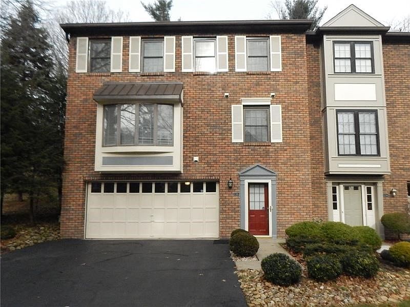 Spacious brick end unit condo with newer windows and a 4 car tandem garage.