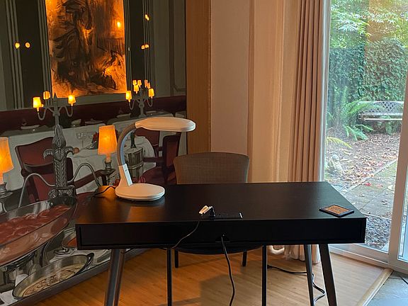 Computer desk with plug ins on top. Designer artwork on back wall with dimmer switch for lighting