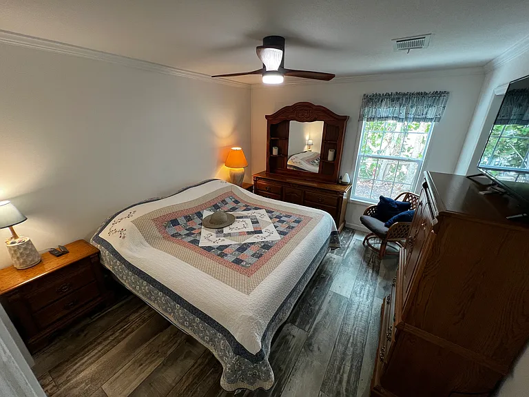 Master bedroom: Sleep Number bed, two dressers, ceiling fan. Looks out to patio in back yard. Has a small view of lake.