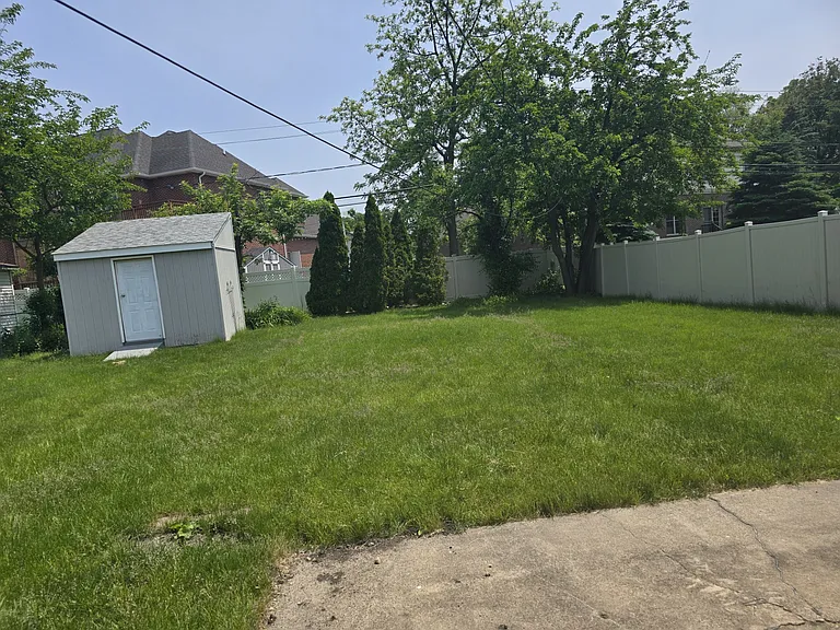 Fenced in yard with a shed