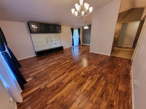 Large front room with entertainment stand and beautiful lighting.