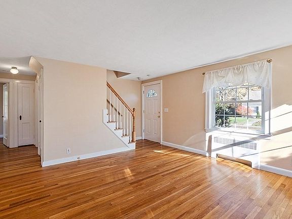 Living Room w/ view of Front Door and Hall to First Floor BR and Office