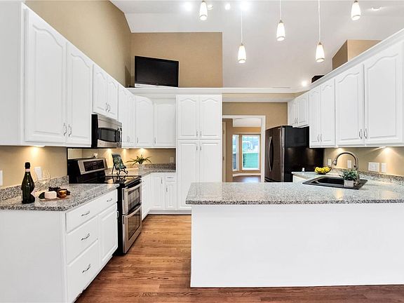 Large kitchen with new granite tops, undermount sink, stainless steel appliances and hard wood flooring. Vaulted ceiling