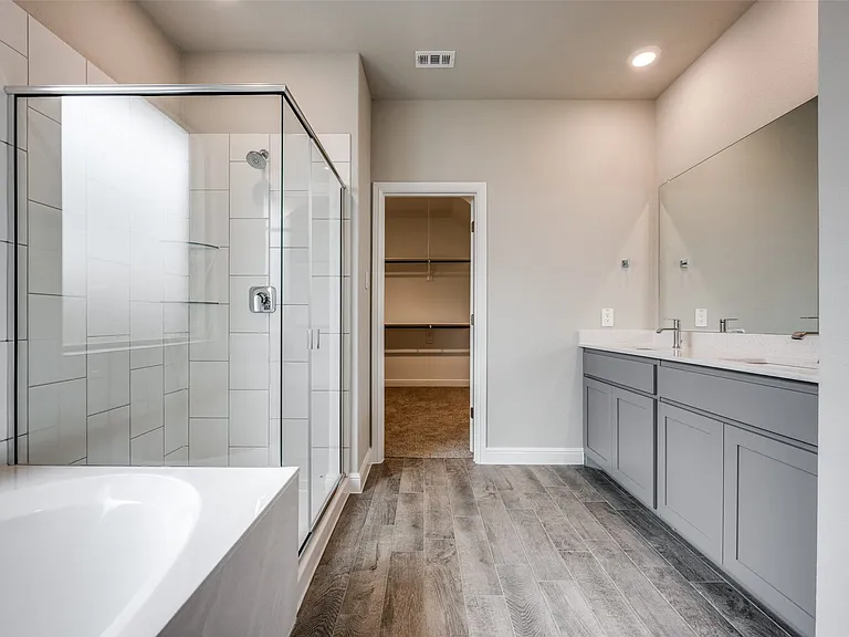 Bathroom featuring vanity, hardwood / wood-style flooring, and plus walk in shower