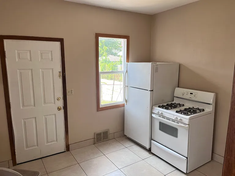 otherside of the kitchen with appliances, along with back entrance.