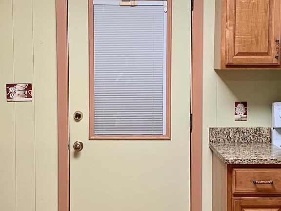 Entry from kitchen to big room. Door has blinds between glasses