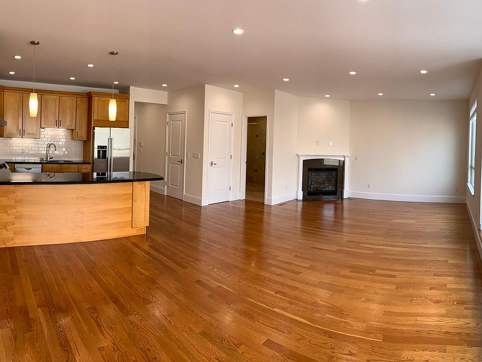 Upstairs great room and kitchen, with a view of the fireplace and huge windows and nook. Laundry closet is directly across from the kitchen.