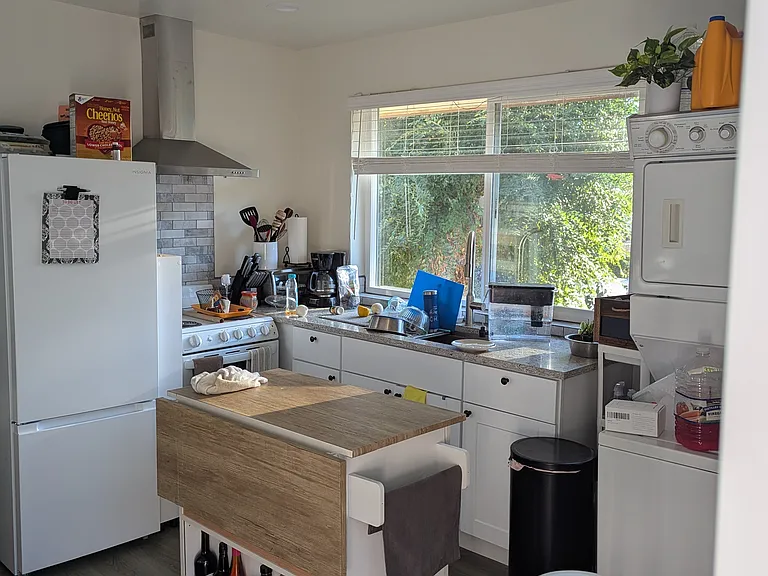 Spacious kitchen with a functional layout, featuring ample room for a central island. Large windows showcase stunning west-valley mountain views and sunsets. Includes a dedicated mini-split for comfort, laundry hookups, and private deck access.