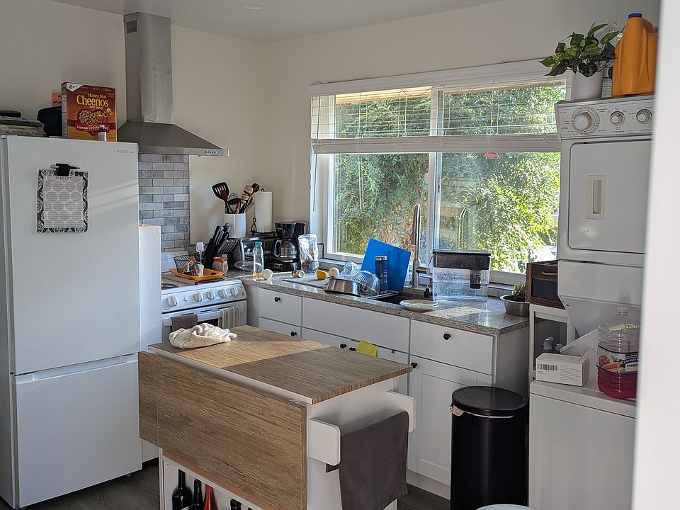 Spacious kitchen with a functional layout, featuring ample room for a central island. Large windows showcase stunning west-valley mountain views and sunsets. Includes a dedicated mini-split for comfort, laundry hookups, and private deck access.