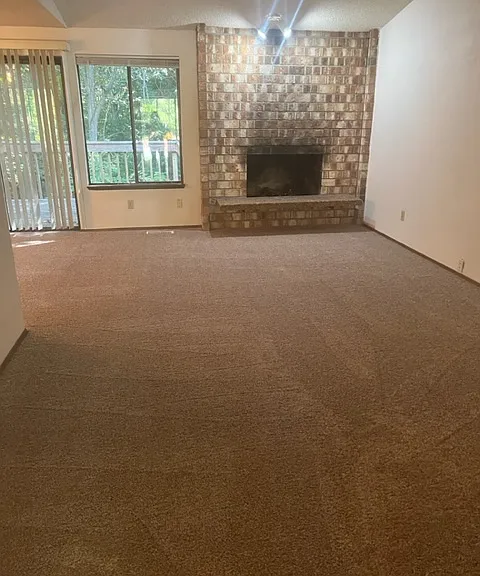 Upstairs living room with wood burning fireplace with new carpet