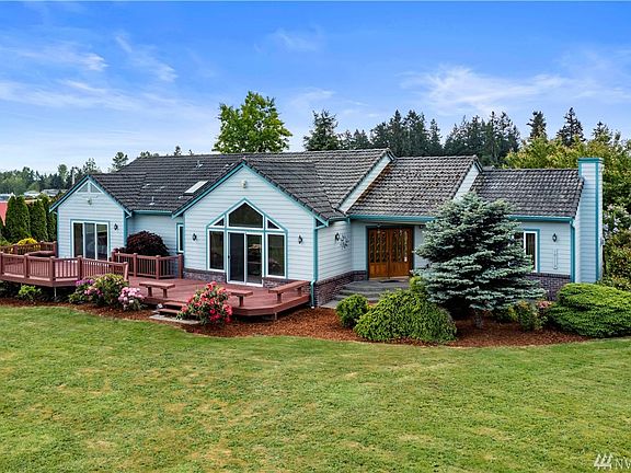 This custom home is nestled on a level 1+ acre lot with beautiful views of Mount Rainier & the foothills