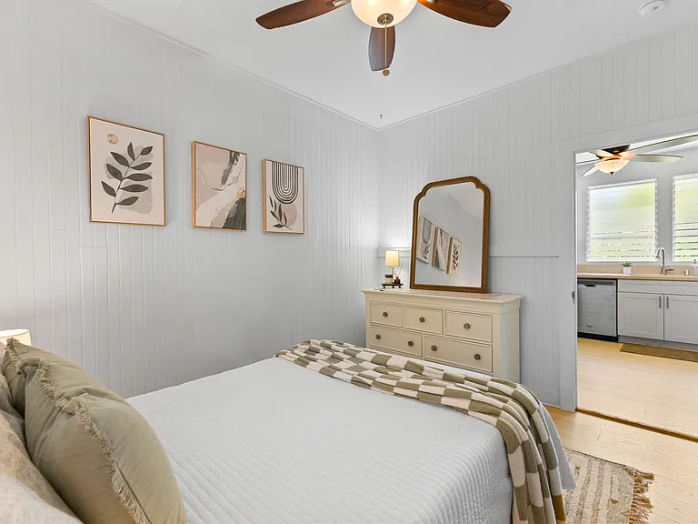 Back bedroom with double bed, AC, ceiling fan, dresser, side tables and large closet with built-in shelving.