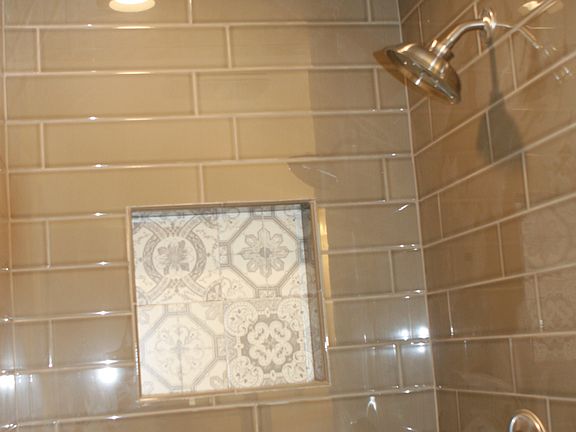Newly tiled master shower with built-in shampoo box