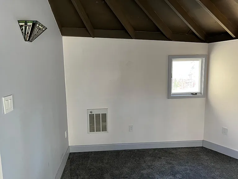Comfortable entry room / living room with upgraded carpet and a tiffany glass sconce.