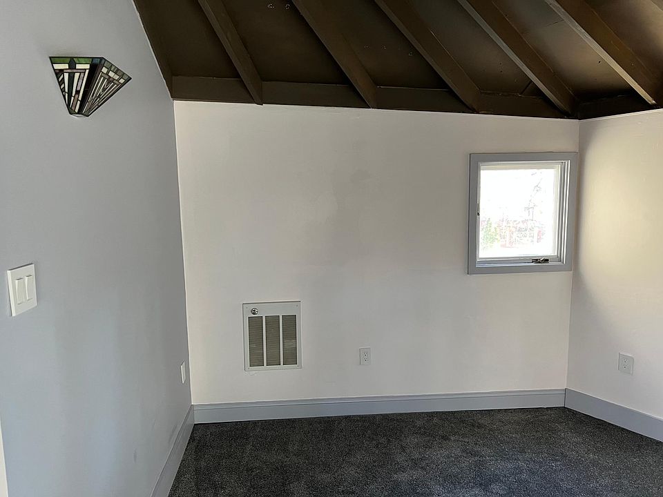 Comfortable entry room / living room with upgraded carpet and a tiffany glass sconce.