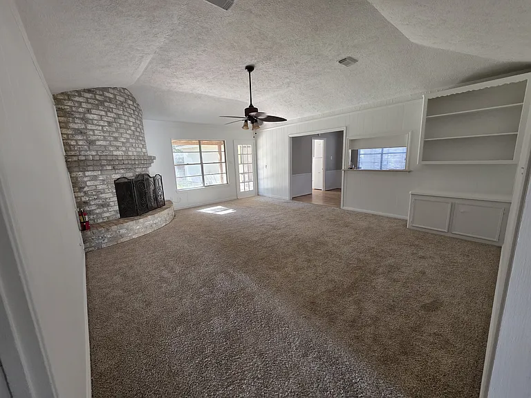 Spacious living / family room with a built-in desk & gorgeous fireplace.