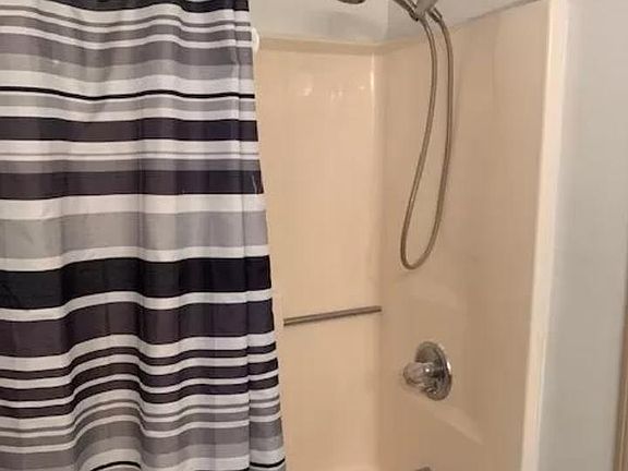 BATHROOM TUB/SHOWER. TILE FLOORS.