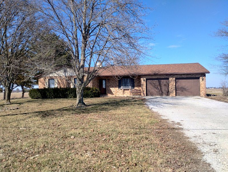 FRONT OF HOME. BRICK FRONT THAT SHOWS 2 CAR GARAGE & SMALL SITTING AREA .