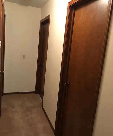 Hallway to Bedrooms with entry to second bedroom and second full bath on right
