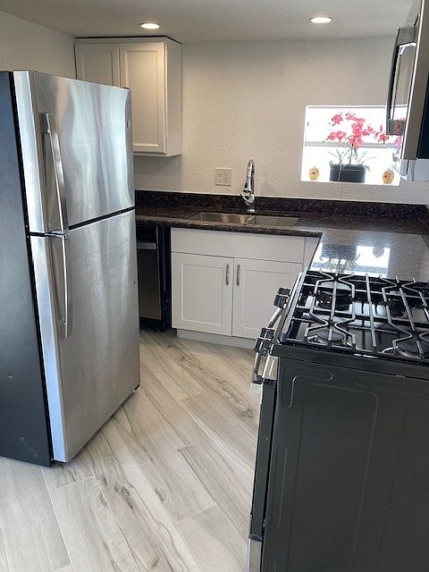 Kitchen. Stainless steel appliances, gas stove, microwave, refrigerator with ice maker, dishwasher, granite countertops . New tile flooring throughout unit.