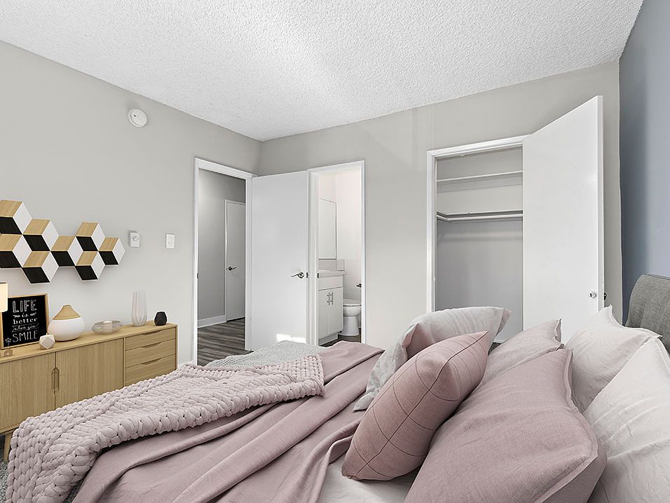 Carpeted bedroom with view of private closet and hall.