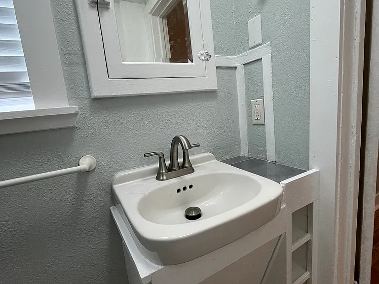 Bathroom sink, medicine cabinet and built in storage.