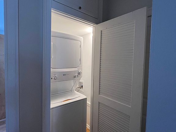 New GE washer and dryer with bonus storage cabinet above laundry closet.