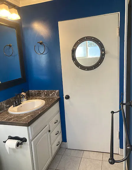Porthole mirror on back of bathroom door.