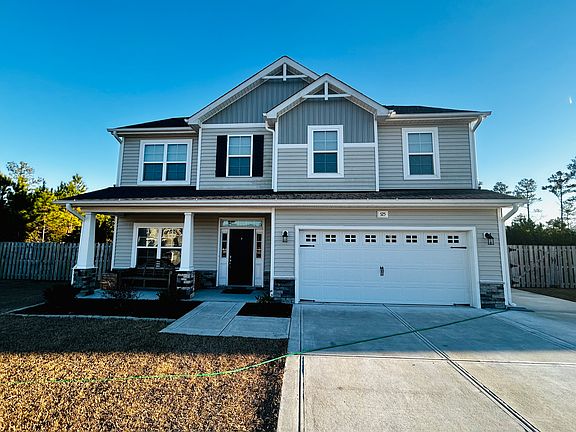 Front of Home _ Two-car garage with an additional driveway extension to the right of the home.