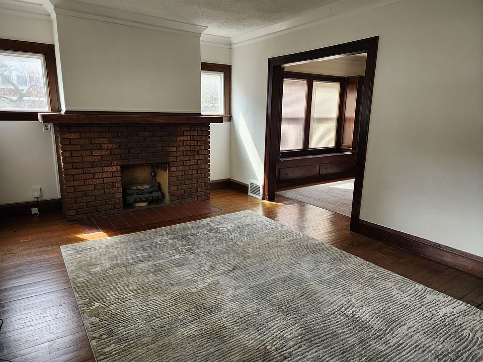Cozy living room with a decorative fireplace with hardwood floor, rug included
