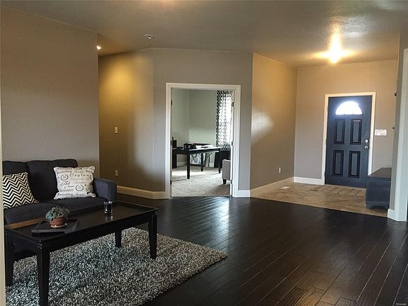 Another view of the formal living room look towards the front door and office space.