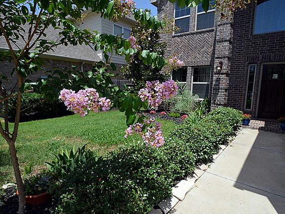 The sidewalk entry to the front of the home is beautifully landscaped with wonderful color.