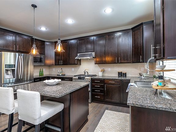 Light and bright kitchen with granite counters and stainless steel Cafe series appliances