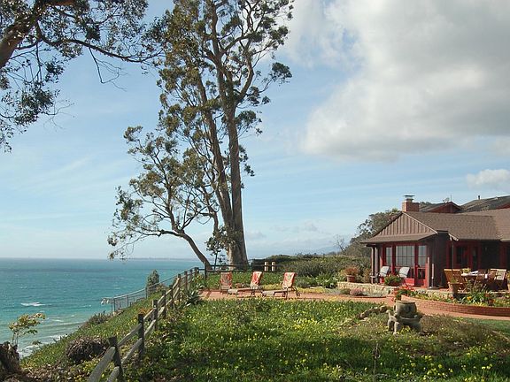 View of back of house with patio and ocean view.