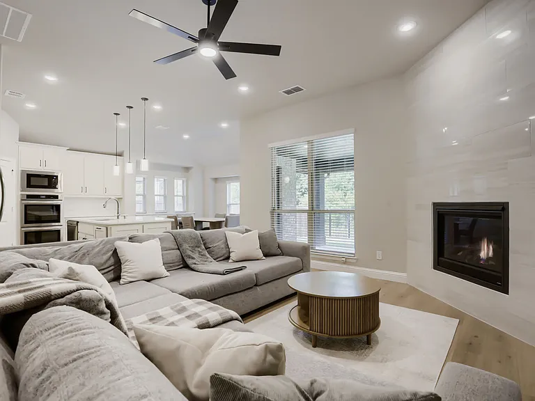 Living area featuring a floor-to-ceiling tiled fireplace, recessed lighting, and a modern ceiling fan