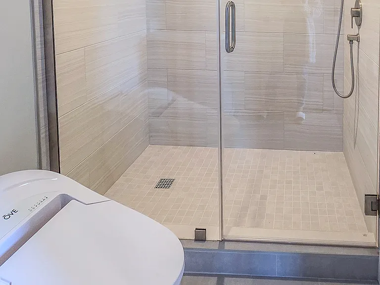 Modern bathroom with glass shower and integrated bidet toilet