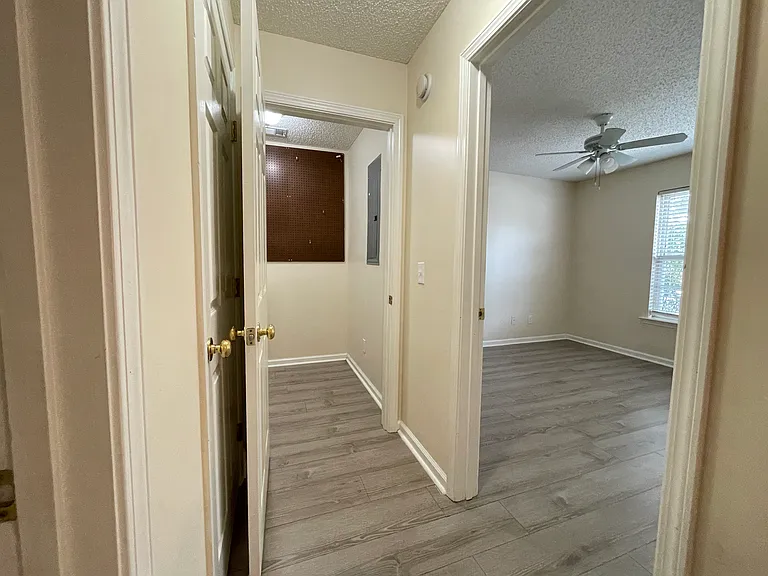 Hallway leading to laundry, hall bathroom, and second bedroom