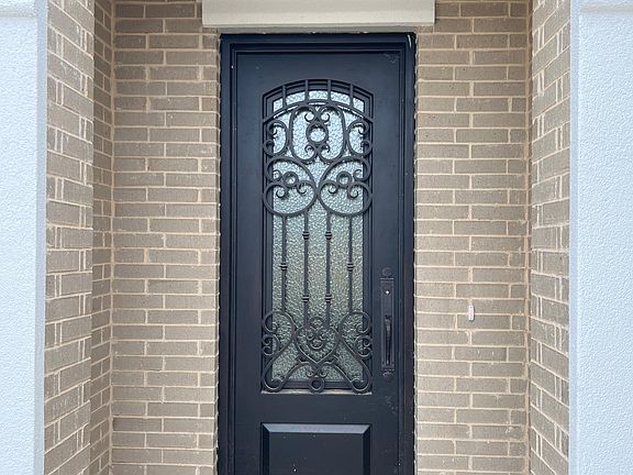 Front wrought iron door with decorative rain glass.