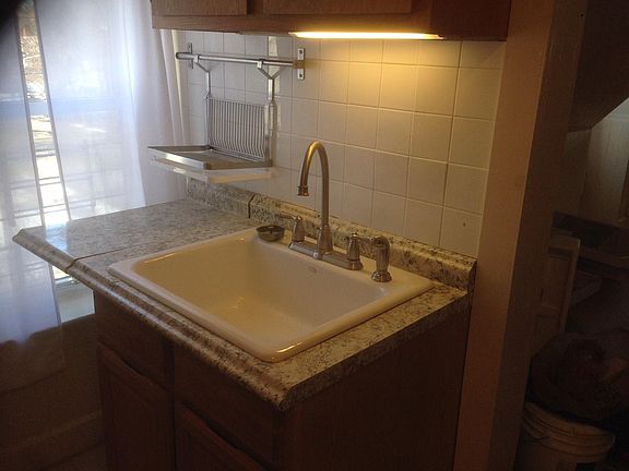 Kitchen features a new deep cast iron sink, faucets, cabinet