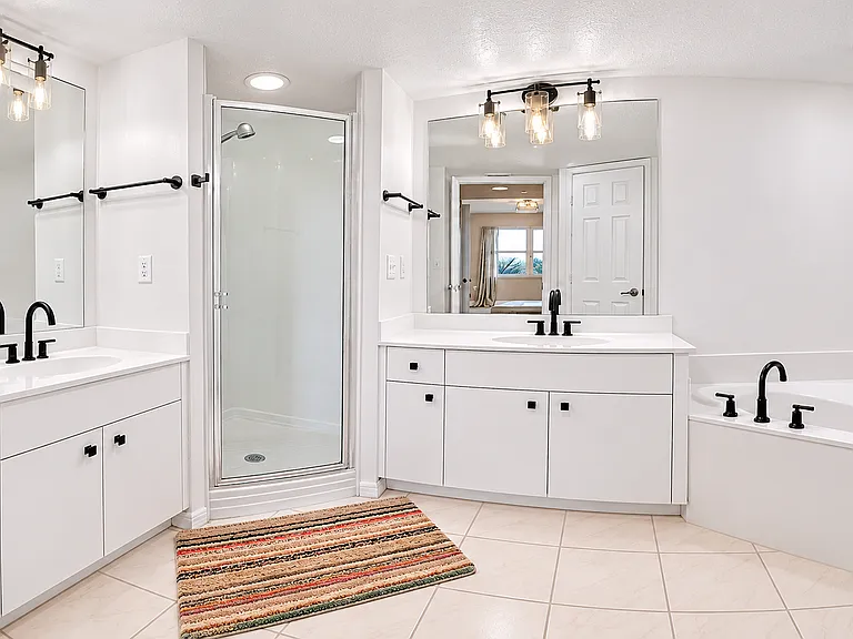 Large primary bathroom with double vanities, walk-in shower, and soaking tub