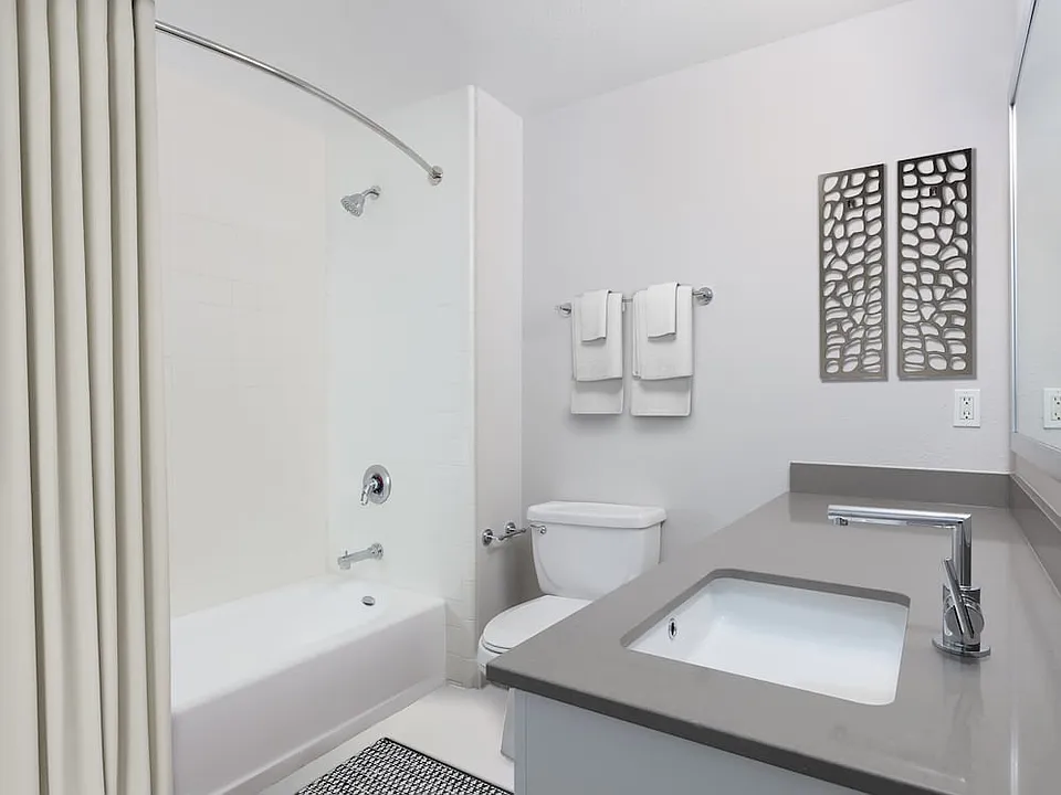 Renovated Phase I bath with quartz countertops and white cabinetry