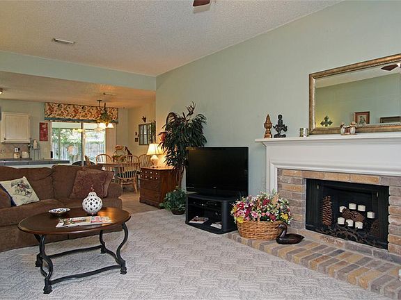 Living room has a wood-burning fireplace with brick surround and lovely wood mantle.