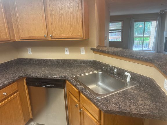 Kitchen area with breakfast bar and overlooking living and dining space